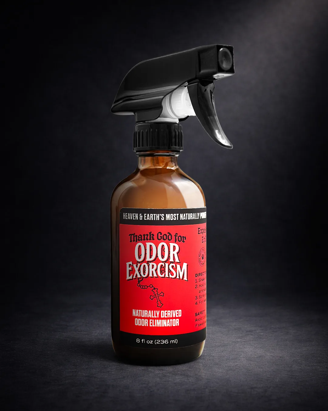 Dramatic, dark-background product photography of an 8 oz bottle of all-natural odor eliminator spray.